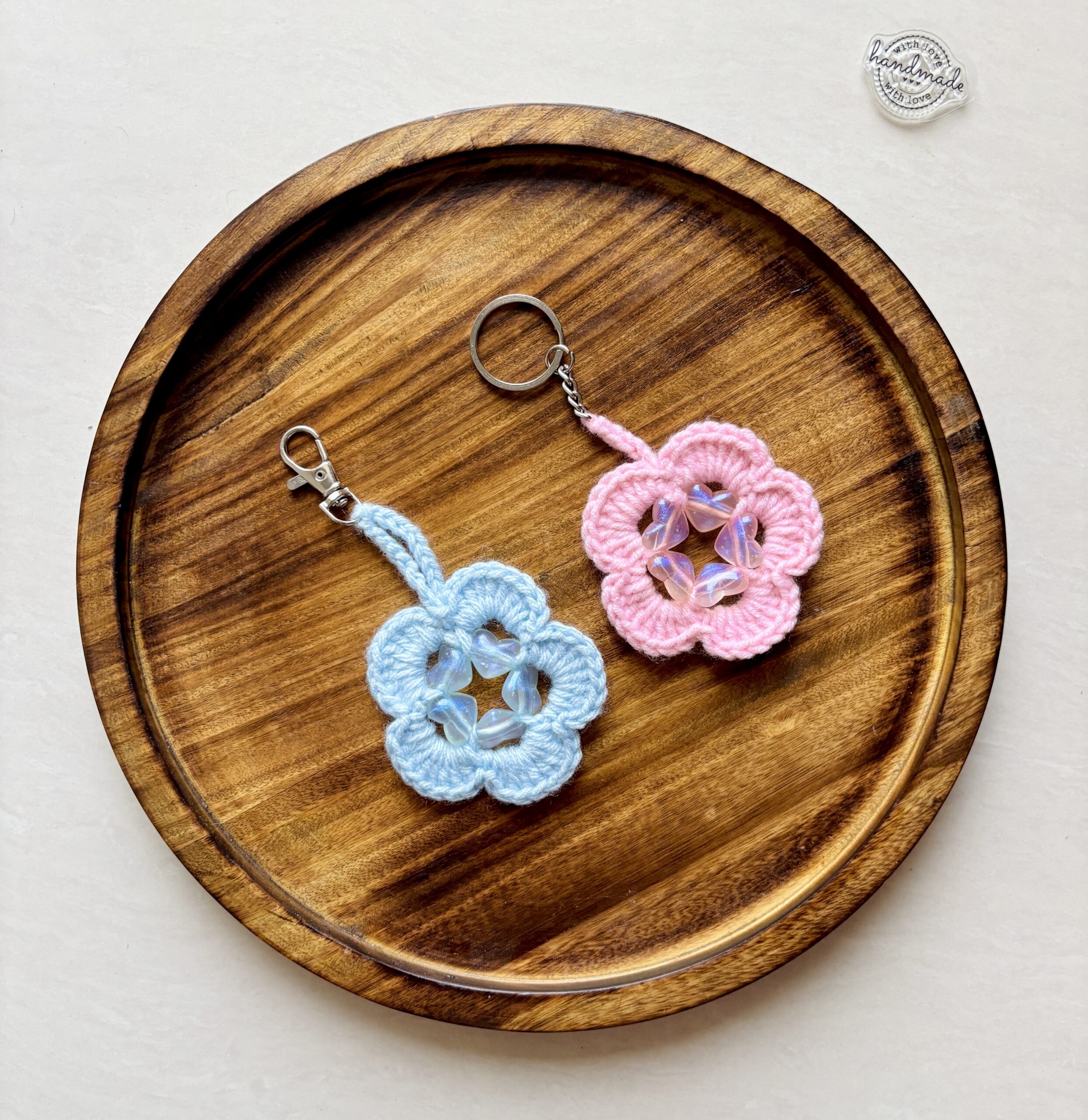 Sweetheart Bloom Crochet Keychains - These delicate crochet flower keychains are designed to capture the beauty of simplicity with a touch of shimmer. Each piece features a pastel-toned bloom, gently accented with translucent beads that catch the light and add a subtle glow.