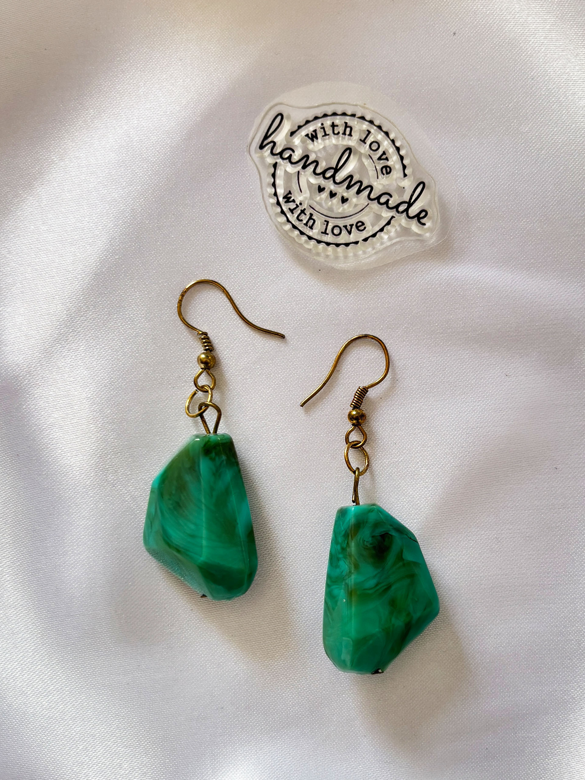 Emerald Drift Earrings - These statement earrings feature unique green marbled beads with organic shapes, making each piece truly one of a kind. Paired with subtle gold accents, the rich emerald tones bring a fresh yet sophisticated touch to your look.