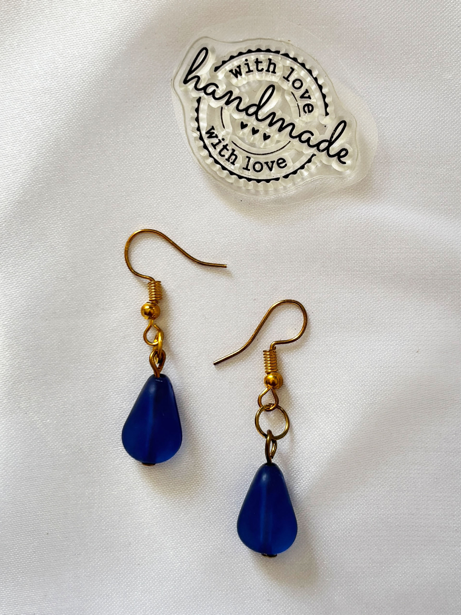 Midnight Drop Earrings - These minimalist drop earrings feature deep blue teardrop beads paired with subtle gold accents—creating a look that’s both timeless and versatile. The rich, midnight hue adds a touch of depth and sophistication, making them perfect for both everyday wear and special occasions.