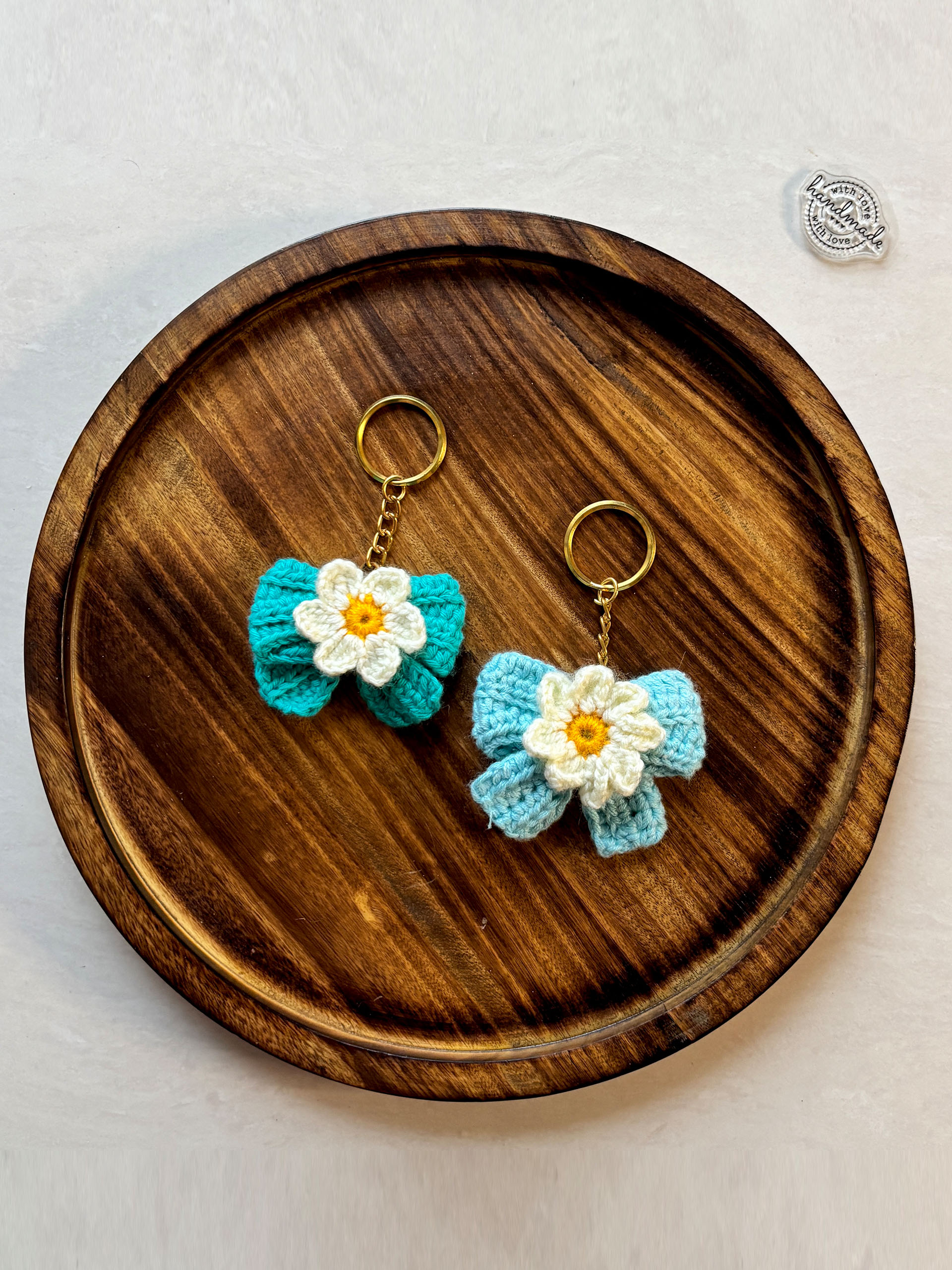 Petal Pop Bow Keychains - Add a little bloom to your essentials with these handcrafted crochet keychains. Designed with a delicate flower resting on a beautifully textured bow, each piece feels like a tiny bundle of joy you can carry everywhere.