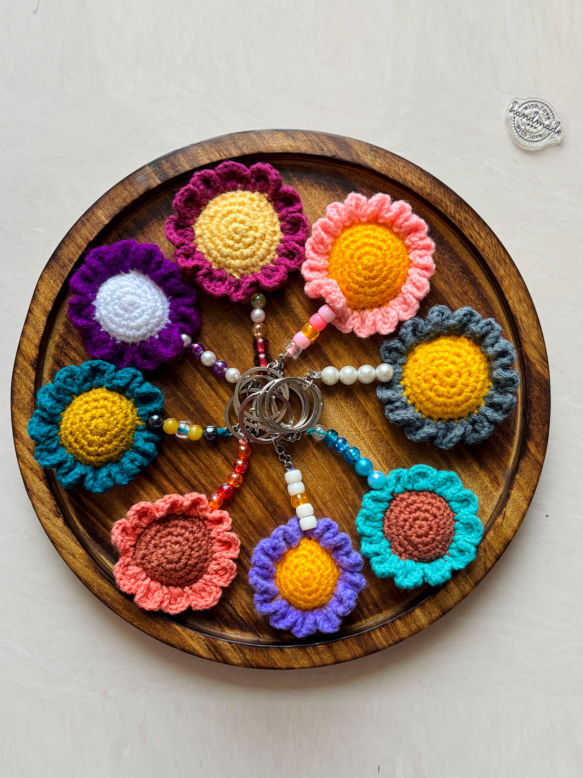 Sunburst Bloom Crochet Keychains - These handcrafted crochet flower keychains are where vibrant colors meet playful charm. Each piece features a beautifully textured bloom paired with colorful beads, creating a cheerful, eye-catching accessory that instantly brightens your day.