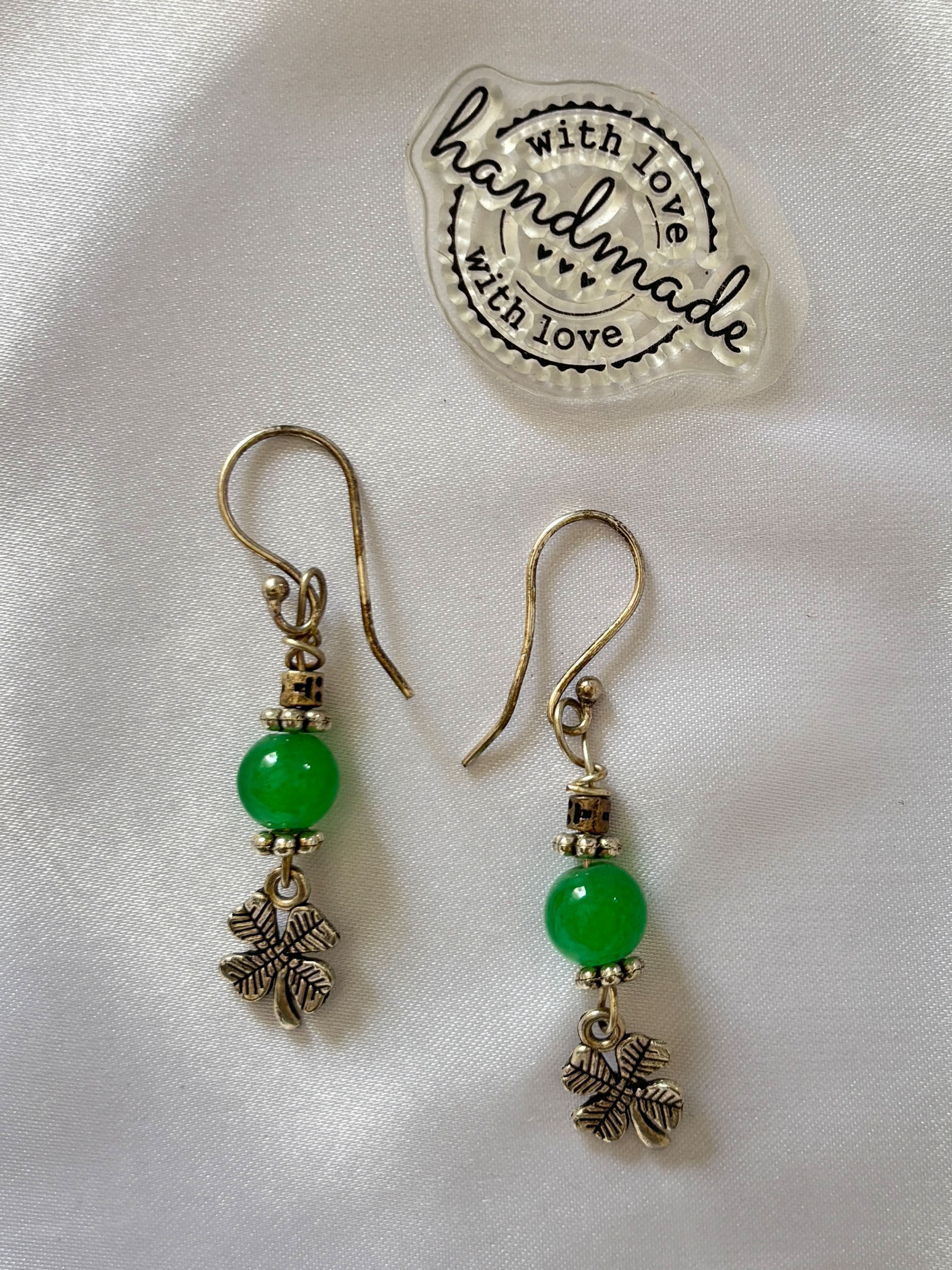Lucky Charm Green Earrings - Elegant with a hint of charm, these green drop earrings bring a subtle yet eye-catching touch to your look. Featuring a rich emerald-toned bead paired with antique-style metallic accents, they strike the perfect balance between classic and playful.